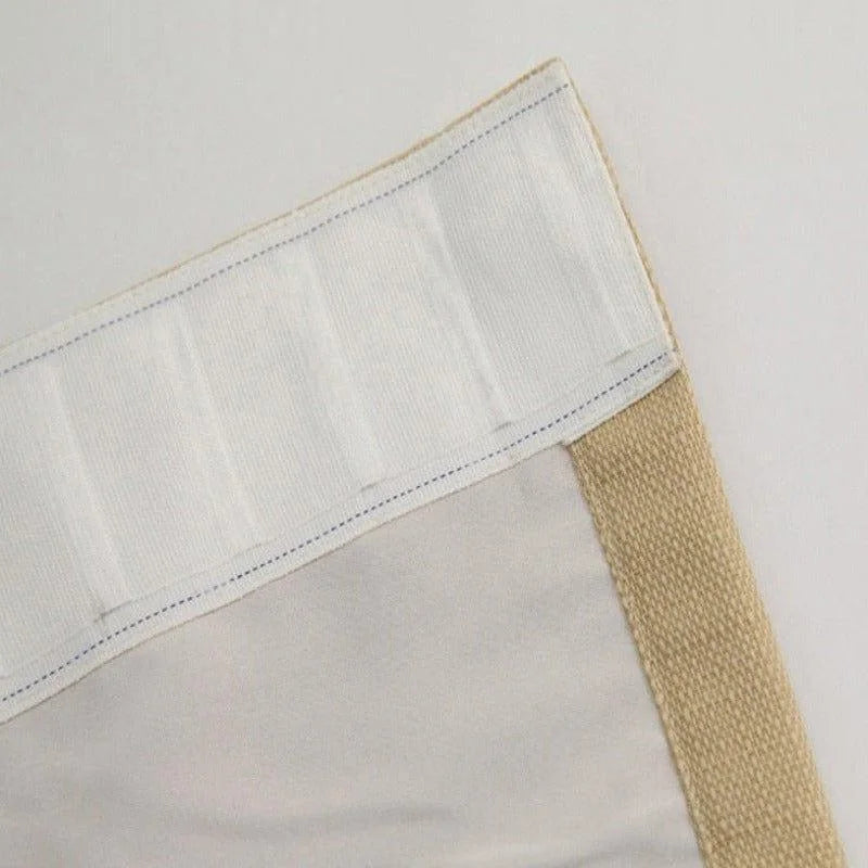 Photo d’un rideau beige et blanc avec bandeau supérieur pour fixation facile. Design épuré idéal pour salons contemporains, apportant élégance et fonctionnalité à votre intérieur. Accessoire décoratif essentiel pour parfaire votre espace de vie.