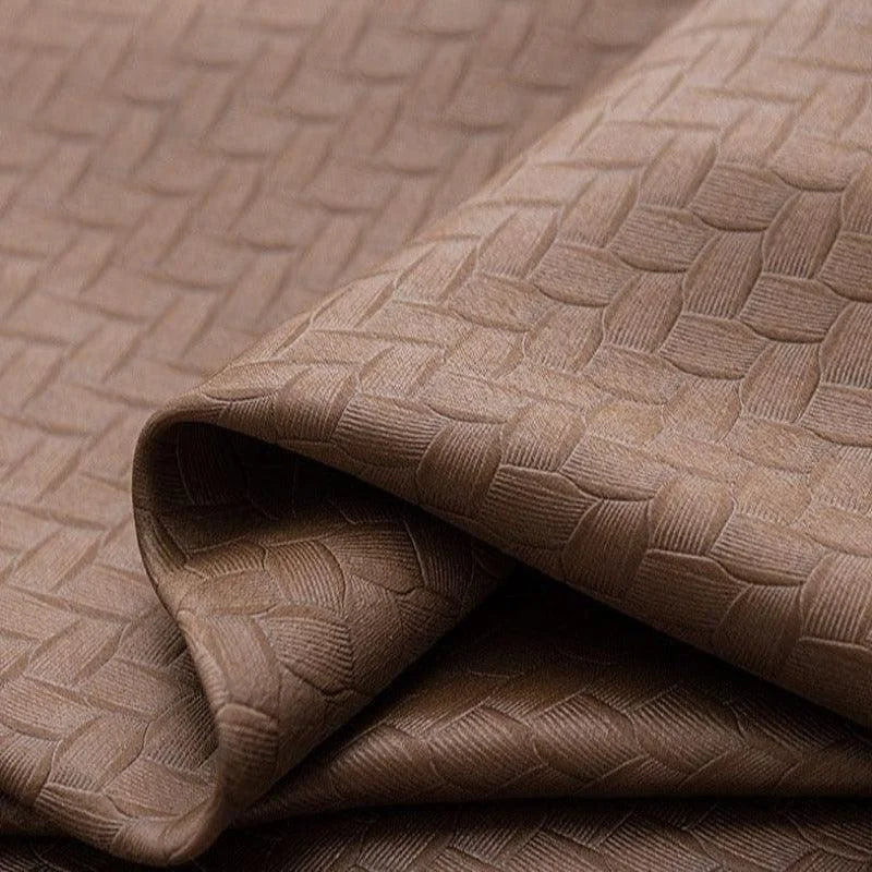 Tissu brun avec motif tressé, idéal pour décoration intérieure. Design élégant et moderne, parfait pour les rideaux, nappes ou housses. Adapté à divers styles d'aménagement grâce à sa texture unique et sa teinte neutre.