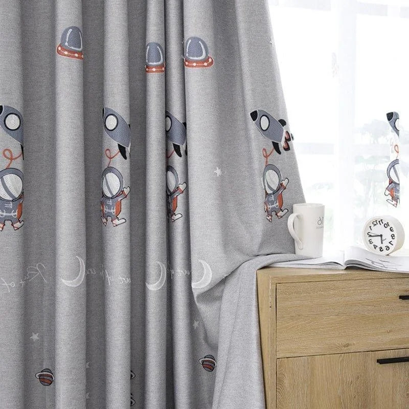 Rideau enfant motif astronautes et fusées sur fond gris, idéal pour apporter une touche ludique et moderne à la chambre de votre petit explorateur de l'espace. Parfait pour stimuler l'imagination et personnaliser la décoration intérieure tout en améliorant l'intimité. Convient aux chambres d'enfants et aux salles de jeux.