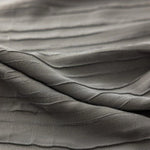 Texture de tissu gris aux plis élégants, idéale pour la confection de vêtements raffinés ou de décorations d'intérieur modernes. Ce design subtil ajoute une touche de sophistication à tout projet créatif.