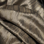 Tissu luxueux avec motifs abstraits élégants, l'idéal pour confectionner des vêtements ou des accessoires raffinés; offre un charme unique avec des nuances dorées et brunes. Parfait pour les projets de décoration ou la haute couture.