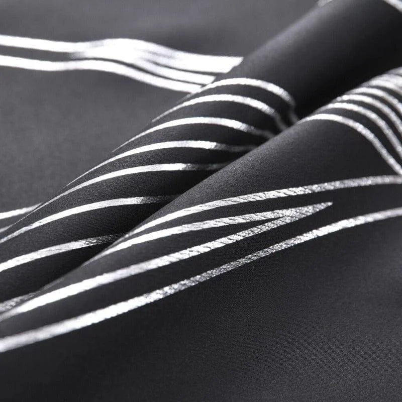 Image gros plan d'un tissu noir avec des motifs de lignes argentées. Design moderne et élégant, idéal pour la décoration intérieure ou la confection de vêtements tendance. Les motifs en lignes ajoutent une touche sophistiquée et contemporaine.