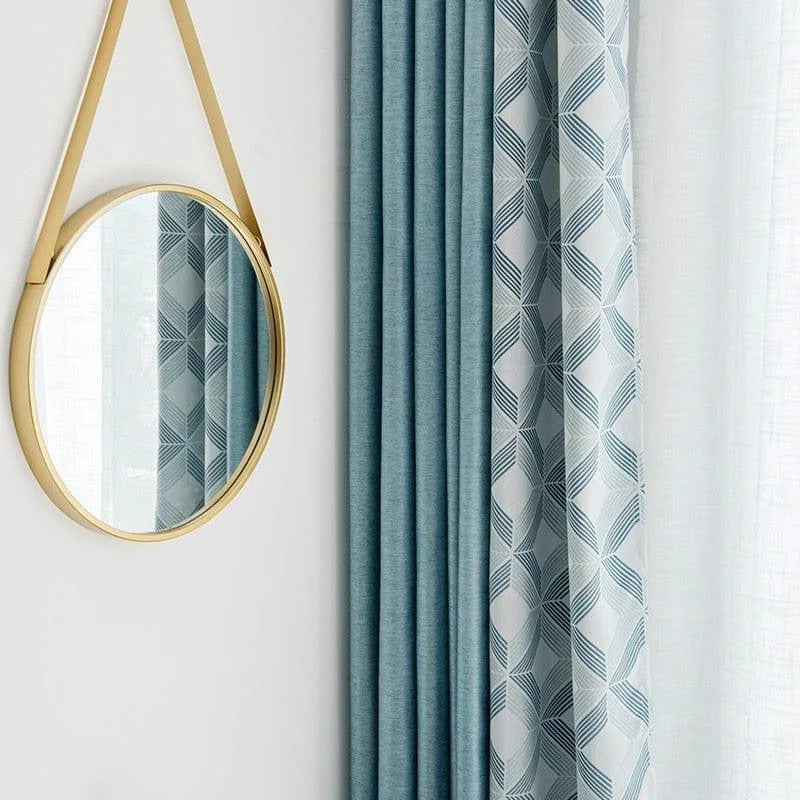 Miroir rond avec cadre doré suspendu à un mur, accompagné de rideaux bleus aux motifs géométriques, créant une ambiance élégante et moderne pour la décoration d'intérieur.