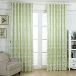 Rideaux élégants vert clair avec motifs subtils pour salon moderne, suspendus à une tringle au-dessus d'une grande fenêtre, apportant une touche raffinée et lumineuse à la décoration intérieure. Ideal pour filtrer la lumière tout en ajoutant du style à votre espace de vie.