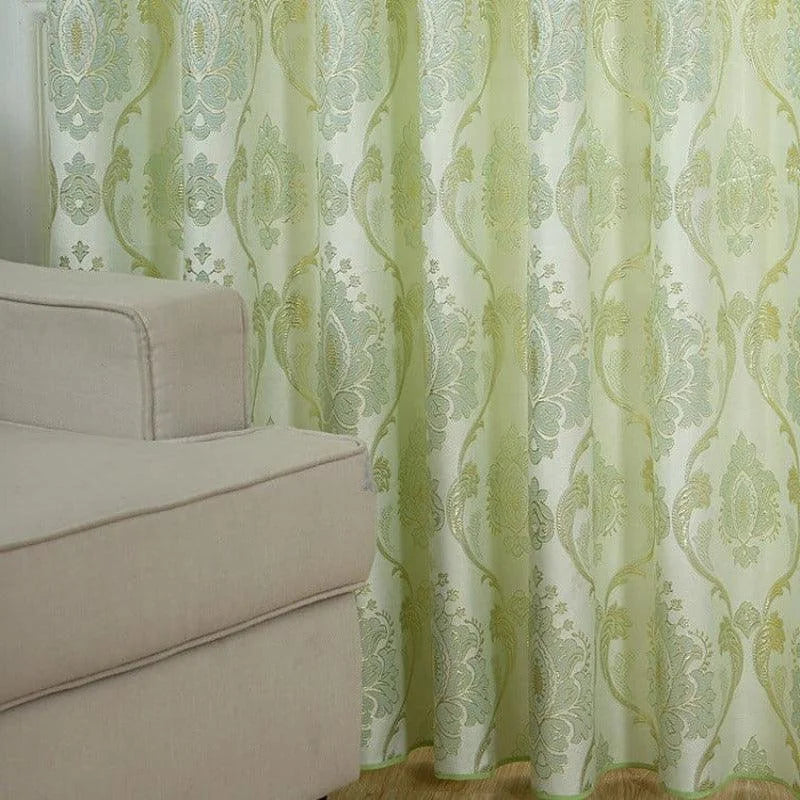 Rideau décoratif vert clair à motifs baroques avec canapé beige, idéal pour salon, apportant élégance et style à votre intérieur moderne.