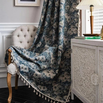 Plaid décoratif à motifs floraux en bleu et blanc, ornant un intérieur élégant avec un fauteuil capitonné et une commode sculptée. Accessoire parfait pour ajouter une touche de charme et de confort à votre salon.