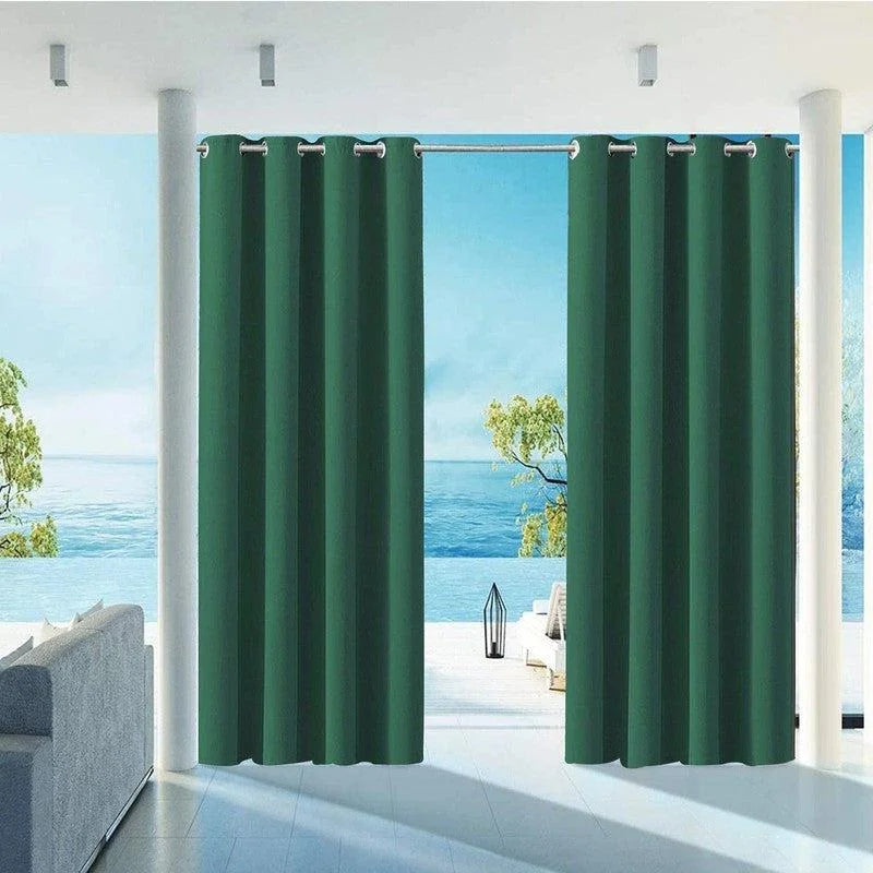 Rideaux verts sombres dans un salon moderne avec vue sur mer, créant un contraste élégant et apportant une ambiance relaxante. Accessoire idéal pour bloquer la lumière tout en ajoutant une touche de sophistication à votre intérieur.