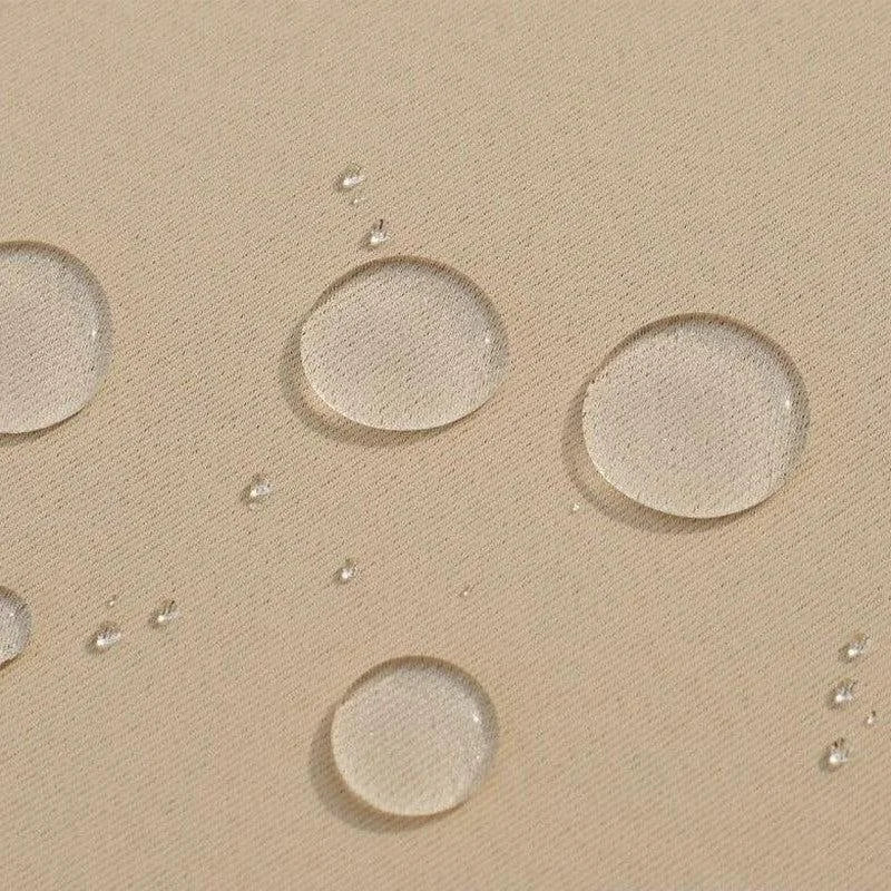 Gros plan sur des gouttes d'eau repoussées sur une surface beige, illustrant l'effet déperlant du produit. Idéal pour démontrer la résistance à l'eau et l'efficacité de la protection contre l'humidité, parfait pour les applications nécessitant une imperméabilité accrue dans des environnements variés.
