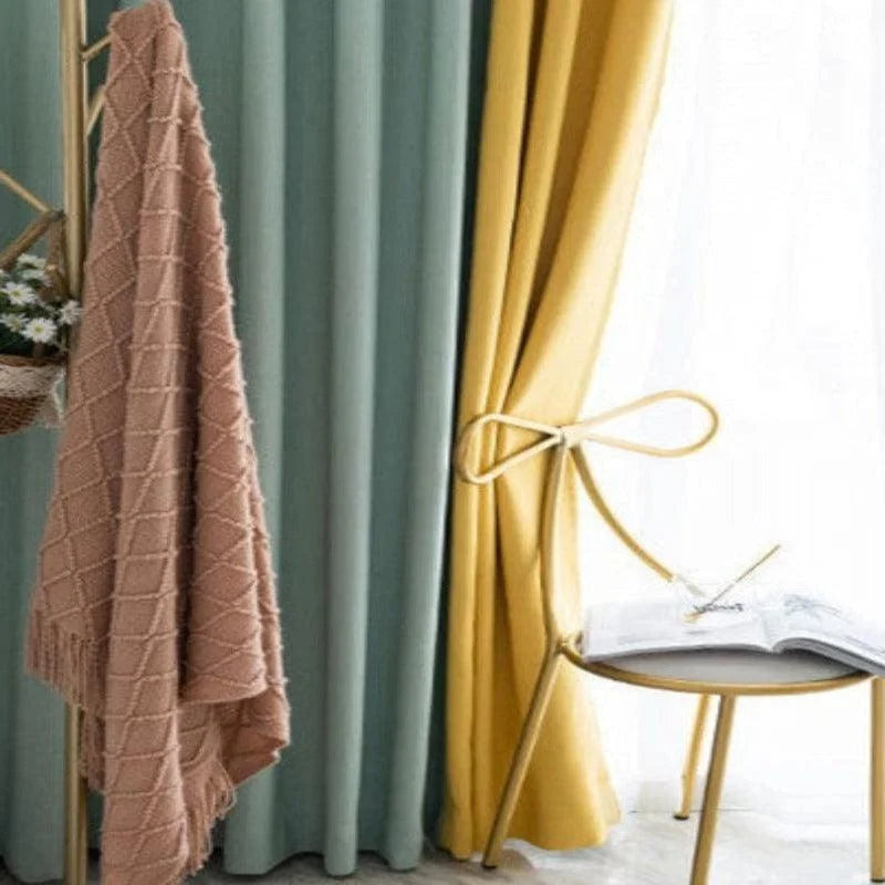 Image d'intérieur présentant une élégante chaise design près de rideaux modernistes turquoise et jaunes, avec un plaid décoratif et un livre ouvert sur une table minimaliste. Créez une ambiance chaleureuse et colorée dans votre espace de vie.