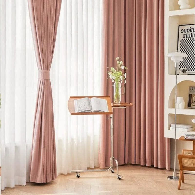 Support de lecture ajustable élégant dans un salon moderne avec rideaux rose pastel et bibliothèque. Parfait pour les amateurs de lecture et les environnements accueillants, apportant une touche sophistiquée et pratique à votre espace.
