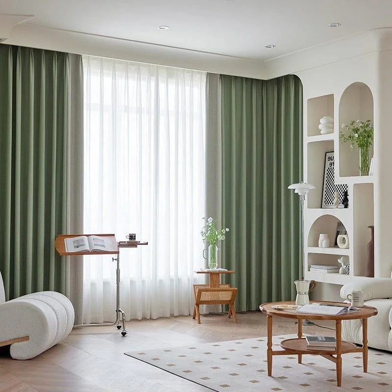 Salon moderne et élégant avec rideaux vert olive, accentuant une ambiance lumineuse et apaisante. Mobilier aux formes arrondies et étagères intégrées apportent une touche contemporaine. Table basse en bois naturel au centre, parfaite pour créer un espace de détente. Idéal pour un intérieur chic et harmonieux.