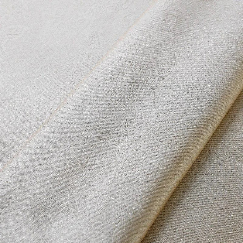 Image d'un tissu brodé clair avec des motifs floraux délicats, idéal pour la décoration intérieure ou la confection de vêtements élégants. Design raffiné et détails subtils pour un style intemporel et sophistiqué.