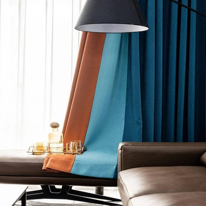 Rideaux élégants en bleu et marron pour salon moderne, combinés à un canapé chic et un éclairage contemporain, ajoutant une touche sophistiquée à l'ambiance intérieure. Décoration raffinée et tendance idéale pour un espace accueillant et chaleureux.