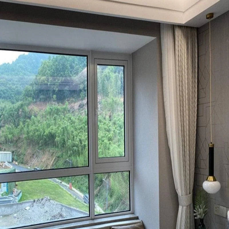 Cette image montre une chambre moderne avec une grande fenêtre offrant une vue panoramique sur un paysage verdoyant. Les rideaux élégants ajoutent une touche sophistiquée à l'intérieur, tandis qu'une lampe suspendue au design contemporain illumine l'espace. Idéal pour créer une ambiance lumineuse et apaisante dans votre maison.