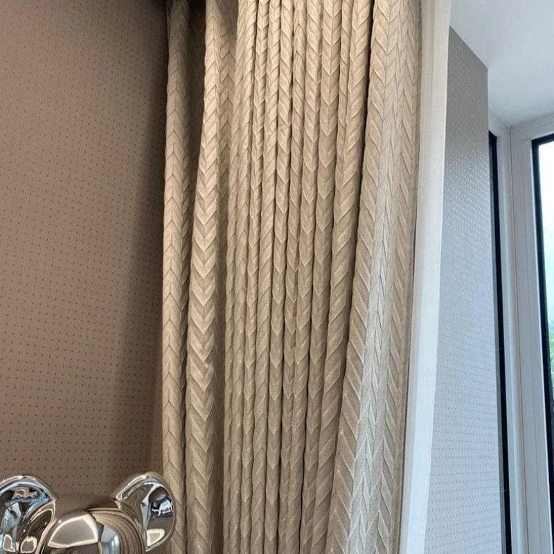 Rideau élégant beige avec motif tressé dans un salon moderne, adjacente à une grande fenêtre lumineuse, apportant une ambiance chaleureuse et sophistiquée à la pièce. Parfait pour la décoration intérieure contemporaine et l'optimisation de la lumière naturelle.