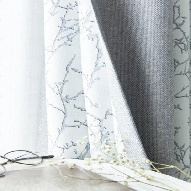 Rideaux élégants en gris et blanc avec motif floral, parfaits pour ajouter une touche de sophistication et de calme à votre intérieur; idéals pour les salons modernes ou chambres à coucher paisibles.