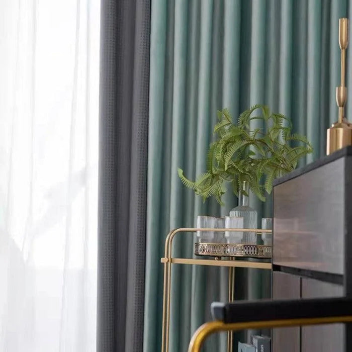 Rideaux élégants avec dégradé de couleurs grises et vertes pour une ambiance raffinée. Beau meuble doré avec plante décorative ajoutant une touche de verdure et de modernité à l’intérieur. Idéal pour salon chic et contemporain. Créez un espace accueillant avec ces éléments de décoration intérieure sophistiqués.