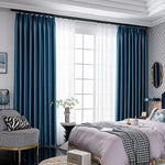 Chambre élégante avec rideaux bleu profond, apportant une touche de sophistication. Ces rideaux offrent un contraste parfait avec le décor moderne de la pièce, accentuant la lumière naturelle entrant par les grandes fenêtres. Idéal pour une ambiance chaleureuse et contemporaine, ce modèle transforme l'espace en un lieu cosy et chic.