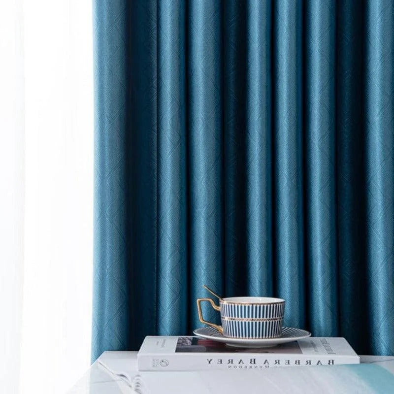 Rideaux opaques bleus, élégants et modernes, parfaits pour ajouter une touche de sophistication à votre intérieur. Idéals pour le salon ou la chambre, ces rideaux bloquent la lumière tout en offrant une esthétique contemporaine. Accessoirisés avec une tasse élégante et un livre, ils créent une ambiance cosy et raffinée.
