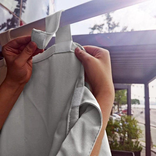 Installation d'un rideau extérieur avec attache pratique, idéal pour protéger les espaces extérieurs du soleil tout en ajoutant une touche décorative. Solution parfaite pour terrasse ou balcon, offrant confort et intimité.