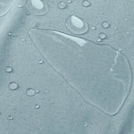 Gros plan sur une surface imperméable avec des gouttes d'eau, illustrant la résistance à l'humidité et la qualité déperlante idéale pour des articles de plein air et des équipements sportifs. Image mettant en avant les propriétés de protection contre les liquides, parfaite pour des vêtements fonctionnels et accessoires durables.