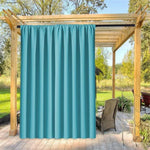 Rideau d'extérieur turquoise suspendu à une pergola en bois, idéal pour créer un espace ombragé et intimiste sur la terrasse. Ce rideau élégant ajoute une touche de couleur vive, parfait pour les moments de détente en plein air. Améliorez votre aménagement extérieur avec cette solution pratique et esthétique.