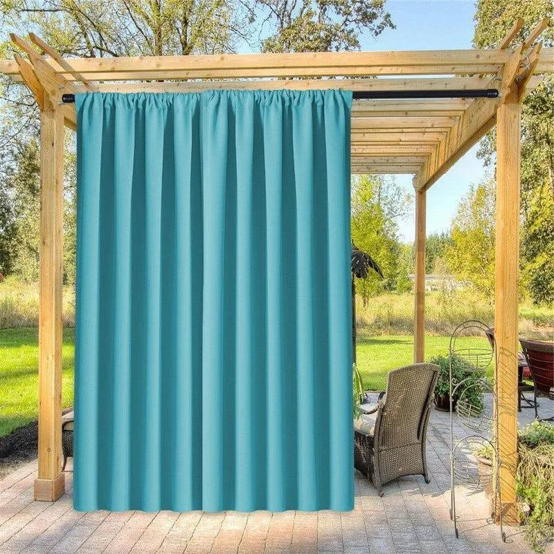 Rideau d'extérieur turquoise suspendu à une pergola en bois, idéal pour créer un espace ombragé et intimiste sur la terrasse. Ce rideau élégant ajoute une touche de couleur vive, parfait pour les moments de détente en plein air. Améliorez votre aménagement extérieur avec cette solution pratique et esthétique.