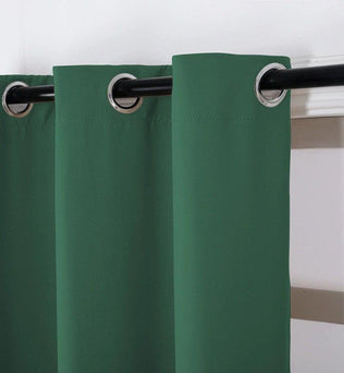 Rideau vert élégant avec œillets métalliques sur tringle noire, idéal pour un salon moderne ou une chambre contemporaine, offrant une ambiance chaleureuse et raffinée.