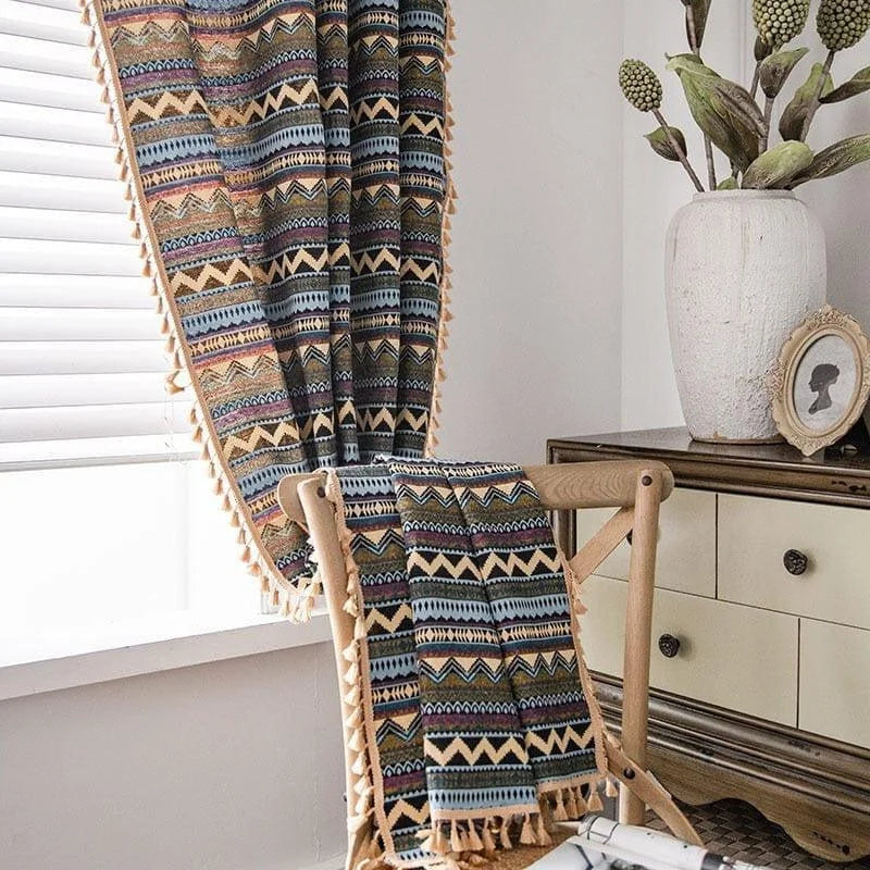 Rideaux à motifs géométriques colorés suspendus dans un salon lumineux. Ces rideaux ajoutent une touche bohème et chaleureuse à la pièce, améliorant la décoration intérieure avec leur style unique et vibrant. Parfait pour apporter de la personnalité à tout espace de vie.