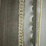 Élégant rideau décoratif blanc avec détails perlés et bordures festonnées, idéal pour ajouter une touche sophistiquée à votre intérieur.
