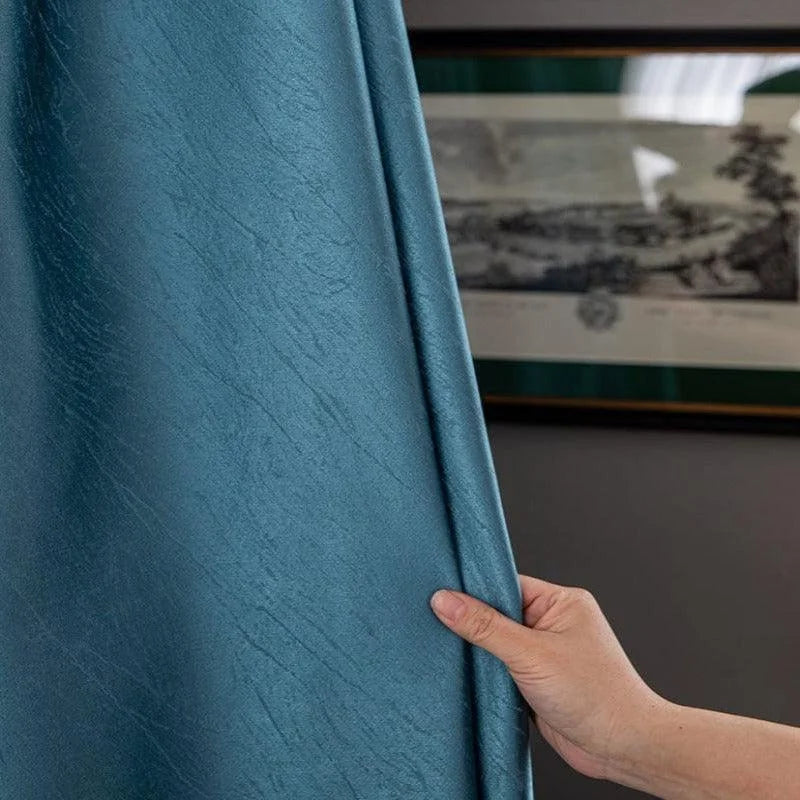 Rideau bleu élégant dans un intérieur moderne. Idéal pour ajouter une touche sophistiquée à votre salon. Design contemporain avec des reflets subtils, parfait pour créer une ambiance apaisante. Facile à installer pour un relooking instantané.