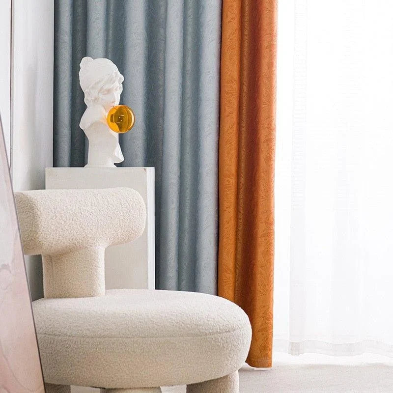 Fauteuil design moderne et élégant dans un intérieur chic, avec rideaux colorés en arrière-plan apportant une touche chaleureuse et artistique. Statue décorative sur un piédestal ajoutant une aura artistique et contemporaine au décor. Idéal pour un salon raffiné ou un espace de travail créatif.