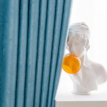 Rideaux occultants bleus élégants pour salon moderne, mettant en valeur une décoration intérieure sophistiquée avec une statue artistique blanche et une bulle colorée. Idéal pour créer une ambiance chic et raffinée dans votre espace de vie.