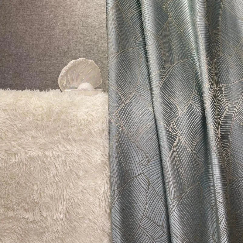Rideau élégant gris argenté aux motifs géométriques, créant une ambiance moderne et sophistiquée dans le salon. Complété par un tapis moelleux blanc, ajoutant une touche de confort et de luxe à votre décoration intérieure. Parfait pour intégrer une note de design contemporain claire et chic à n'importe quelle pièce.
