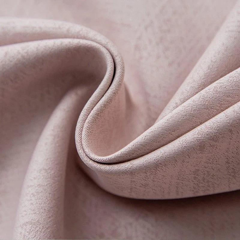 Gros plan sur un tissu rose délicat avec un motif subtil, idéal pour les projets de couture de haute qualité et la décoration intérieure élégante.