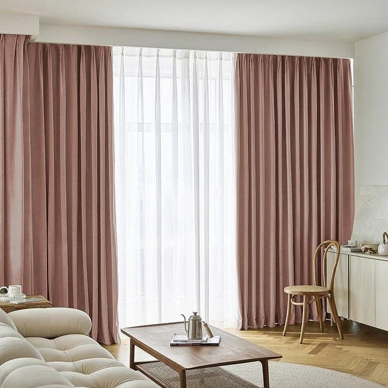 Rideaux opaques rose pâle dans un salon moderne, apportant élégance et chaleur à la décoration intérieure. Cette image montre un espace accueillant avec un canapé confortable, une table basse en bois, et une chaise élégante. Les rideaux ajoutent une touche de couleur douce et raffinée à l'ensemble de la pièce, créant une ambiance chaleureuse et invitante.