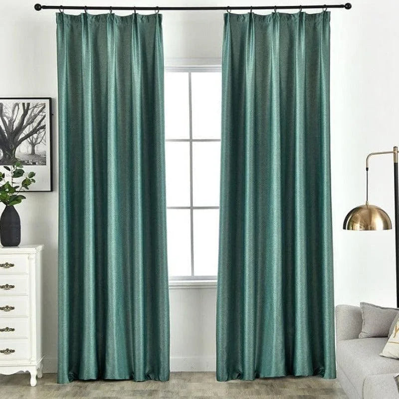 Rideaux élégants de couleur verte suspendus dans un salon lumineux. Accessoire idéal pour une décoration intérieure moderne, offrant intimité et style. Parfait pour les grandes fenêtres, ces rideaux complètent l'ambiance chaleureuse de la pièce.