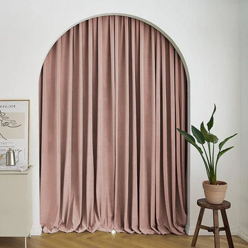 Rideau élégant rose dans un salon moderne. Ce rideau long ajoute une touche sophistiquée à l'intérieur avec son design arqué unique. Idéal pour apporter une ambiance chaleureuse et intimiste à votre espace. Le sol en bois clair et la plante d'intérieur complètent parfaitement le décor accueillant.