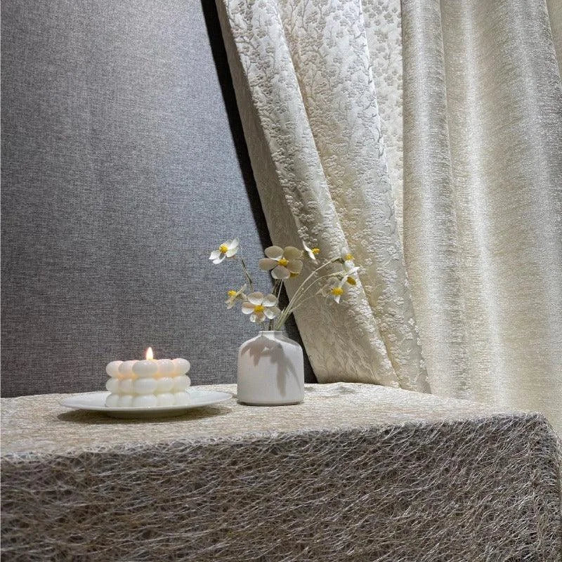 Décoration élégante avec bougie sculptée et vase minimaliste. Ambiance calme et apaisante, idéale pour un intérieur raffiné. Rideaux sophistiqués en arrière-plan ajoutant une touche chic. Accessoires parfaits pour améliorer l'esthétique d'une pièce.