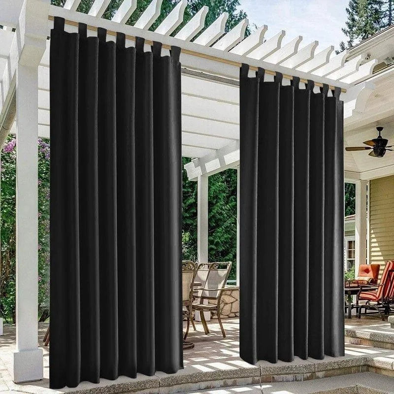 Rideaux extérieurs noirs installés sur une pergola blanche, offrant une solution élégante pour créer de l'intimité et protéger du soleil sur une terrasse aménagée avec des meubles de jardin. Idéal pour améliorer l'esthétique de votre espace extérieur tout en ajoutant une ambiance moderne et accueillante.