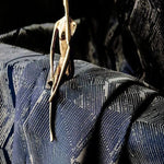 Statue artistique moderne sur tissu texturé bleu foncé, motif géométrique élégant, décoration intérieure contemporaine, mise en scène design pour un intérieur sophistiqué.