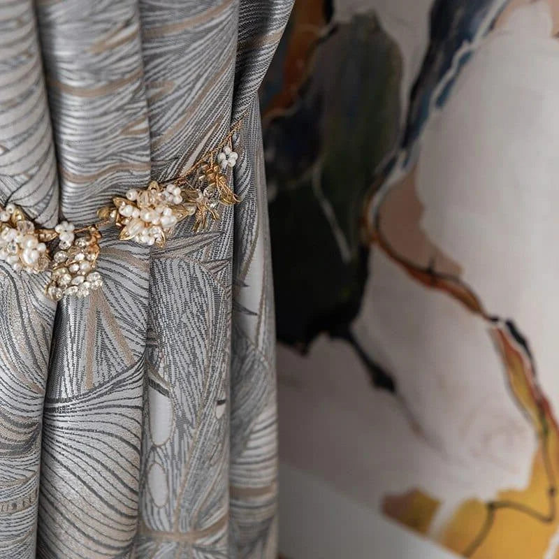 Rideau élégant avec motif artistique en tons de gris, agrémenté d'une embrasse florale délicate, idéal pour apporter une touche sophistiquée et stylée à votre intérieur tout en ajoutant une élément de décoration chic et raffiné. Parfait pour créer une ambiance chaleureuse et moderne dans votre salon ou chambre.