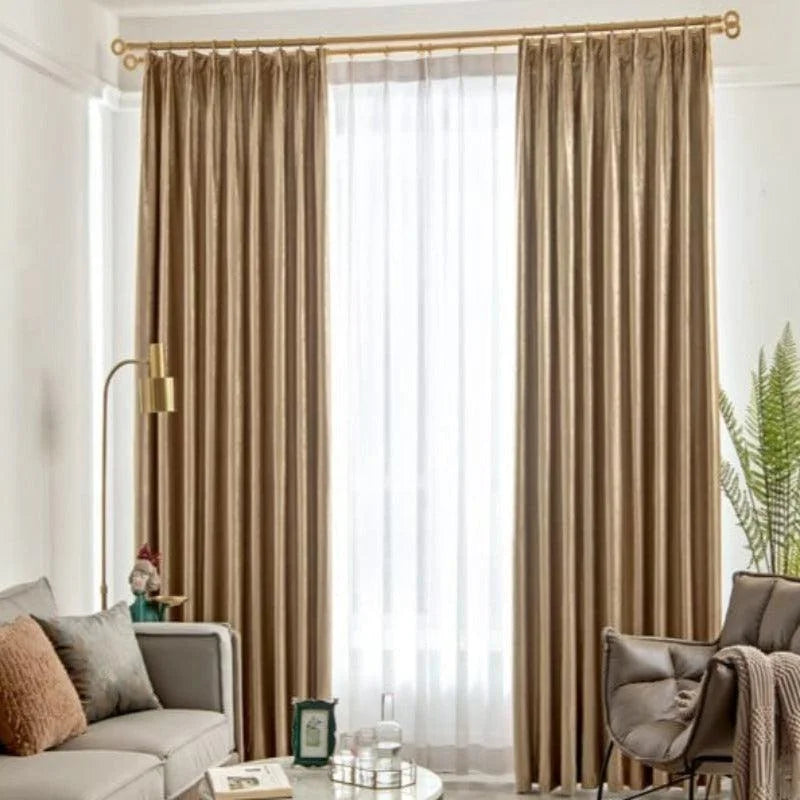 Rideaux élégants couleur beige dans un salon moderne, apportant une touche sophistiquée à la décoration intérieure. Les rideaux tombent gracieusement du plafond au sol, encadrant une grande fenêtre. Le salon est orné de meubles contemporains avec un canapé beige, une lampe dorée et des plantes vertes pour un espace accueillant et harmonieux.
