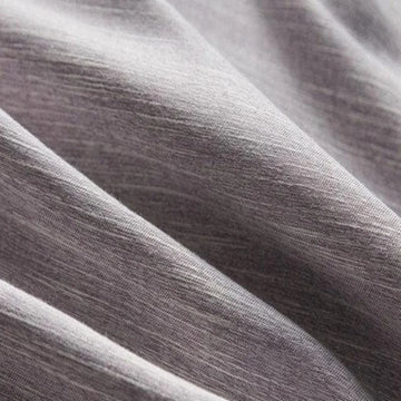 Tissu doux gris aux plis élégants, idéal pour la confection de vêtements confortables et modernes. Design texturé et moderne, parfait pour les créations tendance et stylées.