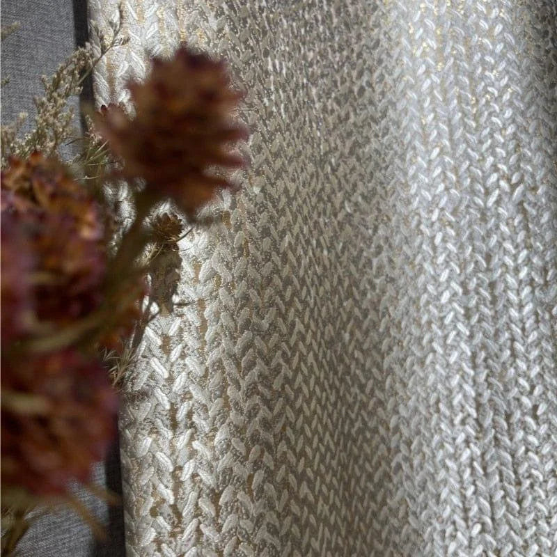 Image d'un élégant rideau d'intérieur avec un motif tissé complexe en teintes dorées et blanches, créant une ambiance chaleureuse et raffinée. Parfait pour ajouter une touche de sophistication à votre décoration intérieure.