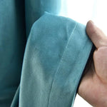 Manche bleue d'un vêtement avec une finition soignée, présentée avec une main pour montrer les détails de couture. Les tons bleu doux apportent une élégance simple et moderne. Parfait pour compléter une tenue chic ou décontractée.