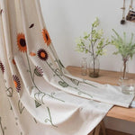 Rideau décoratif avec motifs floraux stylisés, mettant en valeur des fleurs colorées sur fond clair, idéal pour ajouter une touche de fraîcheur et d'élégance à n'importe quelle pièce. Parfait pour habiller les fenêtres et compléter la décoration intérieure d'une maison moderne.