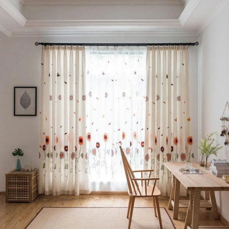 Rideaux élégants avec motif floral coloré dans un salon moderne et lumineux, parfaits pour apporter une touche de fraîcheur à votre décoration intérieure. Fenêtre habillée avec style, complétant un espace de travail au design épuré et nordique. Idéal pour créer une ambiance chaleureuse et conviviale dans votre maison.