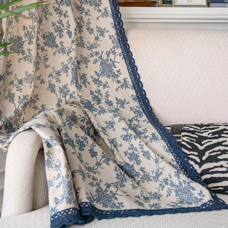 Couverture décorative avec imprimé floral bleu et bordure dentelée, parfaite pour ajouter une touche élégante à votre salon. Idéale pour habiller un canapé ou un fauteuil, cette pièce crée une ambiance chaleureuse et accueillante dans votre intérieur.