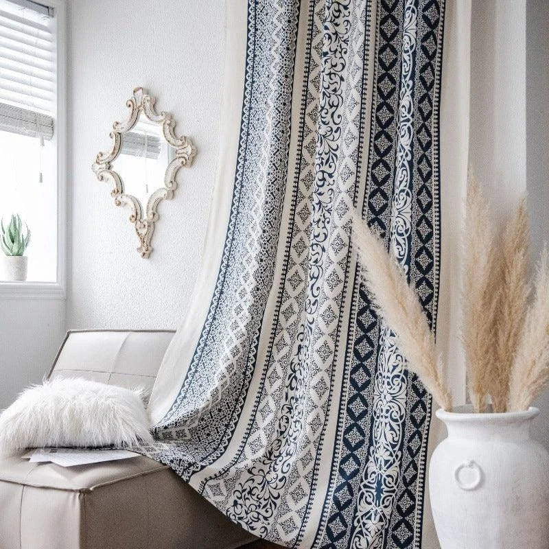 Rideau élégant avec motifs bohèmes suspendu dans un intérieur lumineux, accompagné d'un miroir vintage et d'un vase décoratif. Ambiance chaleureuse et apaisante créée par la présence de plantes vertes et d'un coussin moelleux. Parfait pour une décoration d'intérieur moderne et chic.